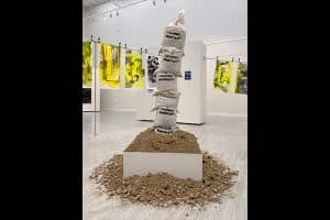 Matt Manalo, Body As A Colonized Vessel, 2019, spray paint on rice bags, dirt from installation location, approx. 60 x 16 inches.
